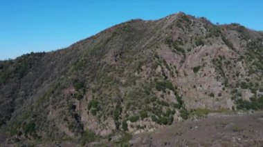 Alpler 'in hava fotoğrafçılığı. Bir helikopteri dağların, kayaların, tepelerin üzerinden uçurmak. Manzara, yeşil çimenler, gökyüzü, bulutlar, doğa, insansız hava aracı videosu. İtalya Capmania.