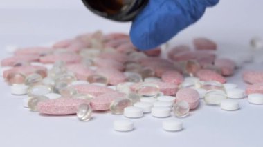 Balık yağı ve diğer vitaminlerle dolu Omega-3 sarı haplar beyaz kağıdın kırışık yüzeyine düşer. Makro. Doğal tıp kavramı. İlaç ve hap ara..