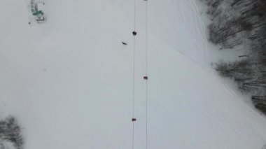 Kayak merkezindeki teleferiğin en üst görüntüsü. İHA, karlı dağlardaki kayak asansörünün üzerinden uçuyor..