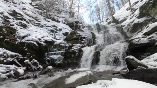 Cachoeira de inverno nos Cárpatos, plano estático. A água bate contra as pedras. Plano global — Vídeo de Stock