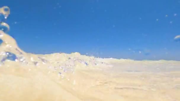 Océano y arena El agua turquesa cubre la lente de la cámara con ondas, cielo despejado sobre el horizonte. Fondo de estilo marino — Vídeo de stock