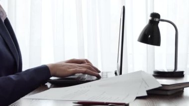 Pencerenin yanındaki masaüstünde dizüstü bilgisayarla çalışan bir adam. Erkek serbest blog yazarı ev ofisinde dizüstü bilgisayarla çalışıyor. İş adamı iş yerinde haberlere göz atıyor