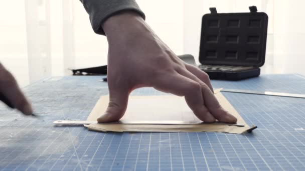 Un sastre masculino corta el primer plano de cuero artificial. Artesano tallando cuero en la mesa de trabajo, haciendo artesanías de piel de animal natural. — Vídeo de stock