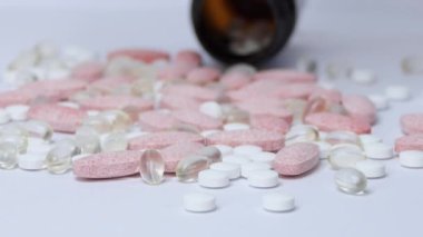 Balık yağı ve diğer vitaminlerle dolu Omega-3 sarı haplar beyaz kağıdın kırışık yüzeyine düşer. Makro. Doğal tıp kavramı. İlaç ve hap ara..