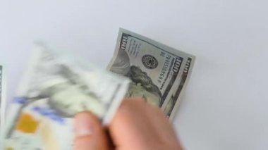 Dünya ekonomik krizi. Bir kadın para sayar. Rüşvet. Kirli para. İki erkek eli beyaz bir masanın üzerine bir yığın kağıt para koyuyor. Masada dolar uçuyor..
