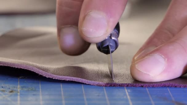 Un sastre masculino corta el primer plano de cuero artificial. Artesano tallando cuero en la mesa de trabajo, haciendo artesanías de piel de animal natural. — Vídeo de stock