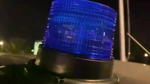 Nödfordonets blå ljus blinkar på fordonets tak. En polisbil står på gatan på taket av bilen blinkande blå — Stockvideo