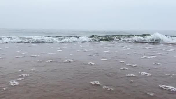Paisagem na praia ondas espumosas em câmera lenta rolando em direção à praia de areia branca sob pouca luz solar. Fundo temático náutico — Vídeo de Stock
