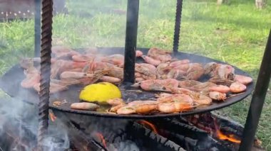 Aşçı ızgaraya soslu karides döker. Kızartma tavasında kızaran kral karideslerinin yakın çekimi. Şef sıcak tavada karides kızartıyor. Yanan arka planda deniz ürünleri