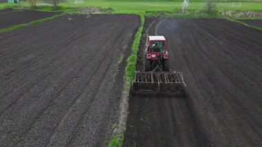 Tarlada tarla sürerken küçük bir traktör tarlası. Tarlada tarla sürme sistemi, toprak izleri, yeni ekin için toprak hazırlama, tarım kavramı, üst görünüm.