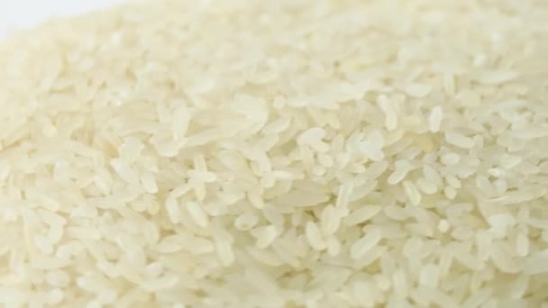 Makró fehér nyers rizs textúra, élelmiszer háttér, vegetáriánus egészséges étkezési termék. Egy halom nyers rizs elforgatása — Stock videók