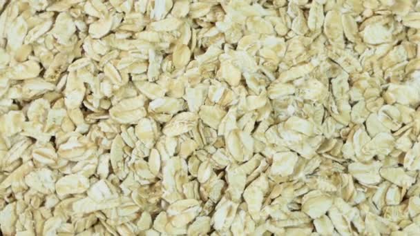 Uncooked oatmeal flakes texture close up. Macro shot. Rotation. Oatmeal. Oat flakes. Close-up rotating. Gastronomy concept, organic food. — Wideo stockowe