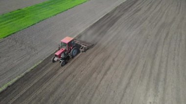 Tarlada tarla sürerken küçük bir traktör tarlası. Tarlada tarla sürme sistemi, toprak izleri, yeni ekin için toprak hazırlama, tarım kavramı, üst görünüm.