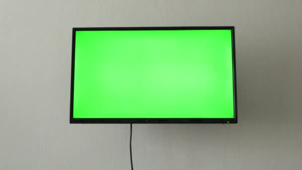 テレビのモックアップ画面。4Kでインターネット上の映画やビデオを見る前に、リビングルームに空白の緑の背景を持つLSDスマートテレビ画面。テレビの緑の画面、部屋、壁に — ストック動画