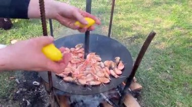 Aşçı ızgaraya soslu karides döker. Kızartma tavasında kızaran kral karideslerinin yakın çekimi. Şef sıcak tavada karides kızartıyor. Yanan arka planda deniz ürünleri