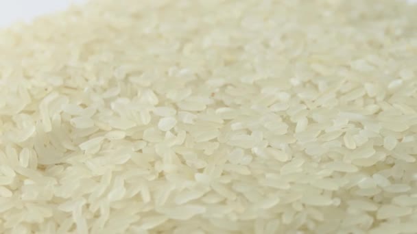 Makro bílá syrová rýže textura, potravinové zázemí, vegetariánské zdravé stravovací produkt. Rotující zblízka hromádka syrové rýže — Stock video