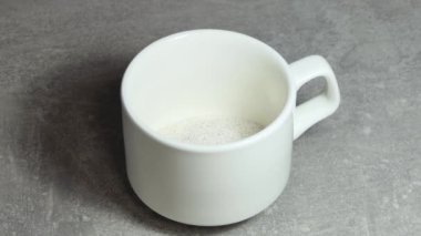 Anında kahve taneleri beyaz bir fincana doldurulur, sonra kaynar suyla doldurulur ve üzerine çikolata serpiştirilir. Hazır kahve..
