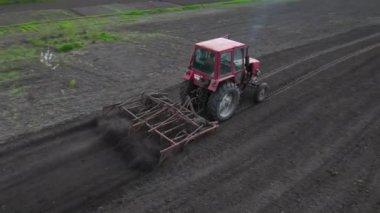 Tarlada tarla sürerken küçük bir traktör tarlası. Tarlada tarla sürme sistemi, toprak izleri, yeni ekin için toprak hazırlama, tarım kavramı, üst görünüm.