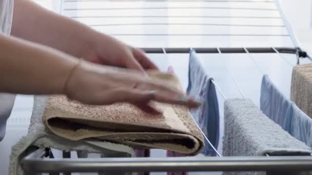 Κοντινές γυναίκες χέρια λαμβάνουν χρωματιστές πετσέτες στο στεγνωτήριο και διπλώστε τους. Πλύσιμο ρούχων. Γυναίκα που κάνει δουλειές του σπιτιού — Αρχείο Βίντεο