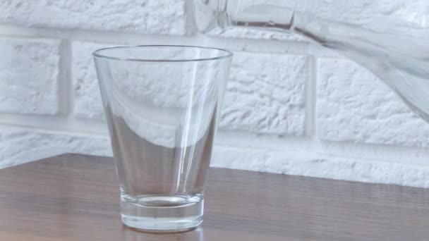 Pure water is poured into a glass cup from a transparent decanter close-up. Transparent glass for filling with fresh drinking water. Thirst quenching concept. High-quality shooting in 4k format — 비디오