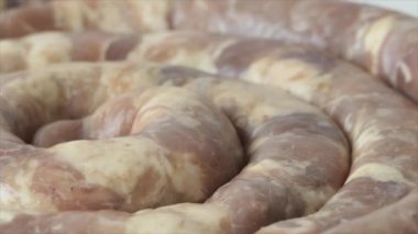 Çiğ ev yapımı sosis kesim tahtasının üzerinde yatıyor. Barbekü için et tabakları. Ev yapımı taze sosis. Sağlıksız ve yağlı yiyecekler. Beslenme kavramı.