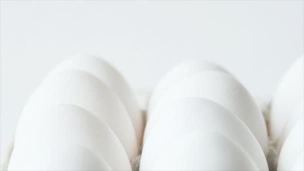 Ägg i en kartong som snurrar vita hönsägg i en kartong. Färska kycklingägg i äggbehållare — Stockvideo