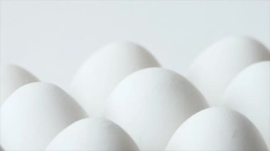 Eggs in a carton, spinning white chicken eggs in a carton. Chicken white fresh raw eggs in egg container