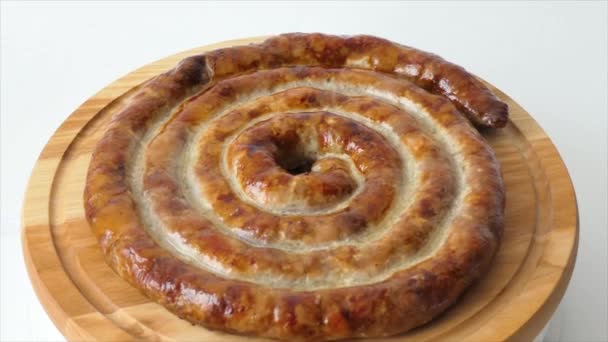 Hot homemade sausage lies on the cutting board. Sausage on a wooden board. Barbecue meat dishes Grilled sausages, homemade fresh sausage spinning on a plate. — Stockvideo