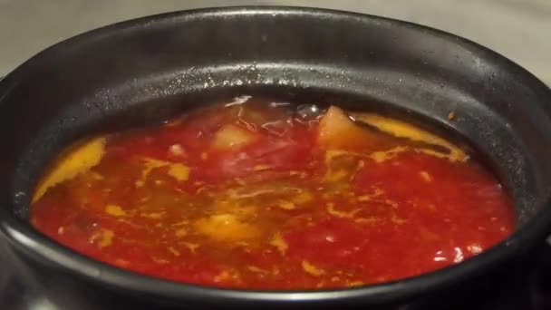 Большой горячий горшок домашнего красного борща. Вариант свеклы, помидоров и капустного супа. Борщ кипит в кастрюле на плите. — стоковое видео