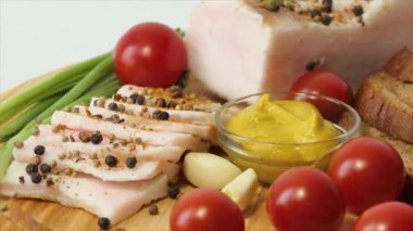 Kesme tahtasında doğranmış domuz yağı büyük bir parça deri ve kırmızı biber serpiştirilmiş baharat. Hardal, kiraz domatesleri, sarımsak, yeşil soğan, siyah ekmek..