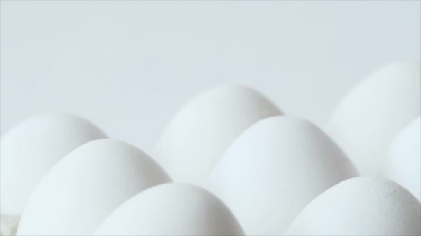 Яйця в коробці, обертаються білими курячими яйцями в коробці. Курячі білі свіжі сирі яйця в яєчній тарі — стокове відео