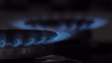 Gaz düğmesi açık ve mutfaktaki ocağı yakıyor. Doğal gaz kavramı.