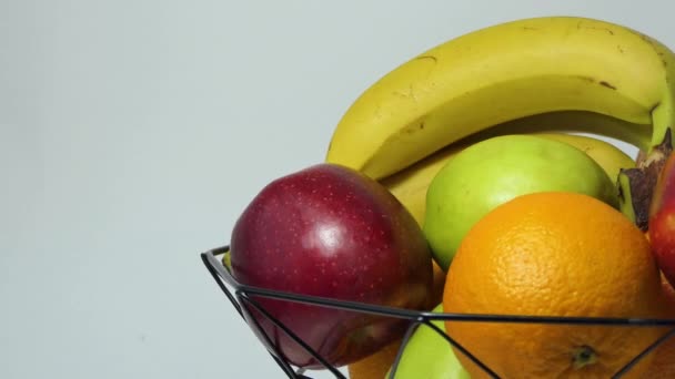 Obrotowy kosz owoców ze świeżymi bananami, jabłkiem, pomarańczą i grejpfrutem dla zdrowego stylu życia. Witaminy w owocach. Koncepcja zdrowej żywności. — Wideo stockowe