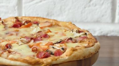 Pizza tabakta dönüyor, arka planda. Lezzetli biberli pizzayı yakından çek. Fırında mozzarella pişiriliyor. Lezzetli İtalyan pizzası - yiyecek ve içecek 4K görüntü