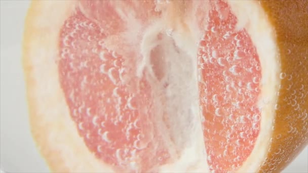 그레이프프루트 (Grapefruit) 는 근접 시식 또는 수면으로 떠오른다. 분홍빛 자몽 반쪽 이물 속으로 떨어진다. — 비디오