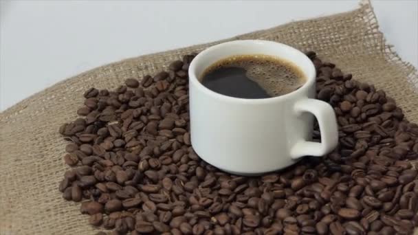 Vit Kopp Med Kaffe Bakgrunden Färska Rostade Kaffebönor — Stockvideo