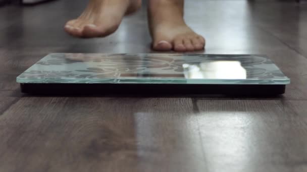 体重計で女性を測定します 女の子の足のステップバスルームスケール フィットネスダイエット女性の足は部屋に体重計を立っている 女性ダイエットチェックBmi減量 裸足測定器 — ストック動画