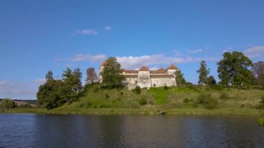 Göl kenarındaki tarihi şatonun, Svirzh kırsalındaki ortaçağ mimarisinin ve kültürel yapısının, ılık güneşli bir yaz gününde Lviv Ukrayna yakınlarındaki hava aracı görüntüleri. Turizm ve seyahat eğlencesi.