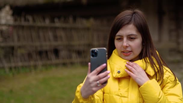 The girl communicates by video on the phone — ストック動画