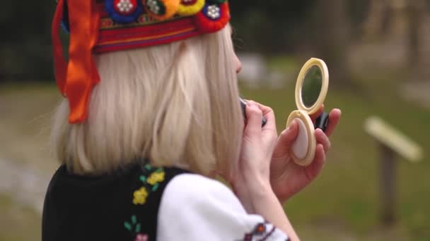 La fille peint ses lèvres devant un miroir — Video