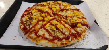 Peynirli dilimlenmiş pizza, tavuk, mısır, tatlı biber ve maydanoz. İtalyan mutfağı.
