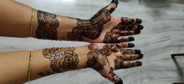 Kadının eli, üzerinde kınalı ve tırnakları olan bir çift güzel Afrika Amerikan ipeği çiziyor.