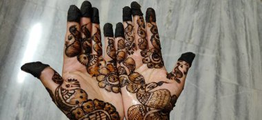 Kadının eli, üzerinde kınalı ve tırnakları olan bir çift güzel Afrika Amerikan ipeği çiziyor.