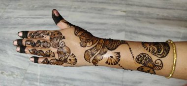 Kadının eli, üzerinde kınalı ve tırnakları olan bir çift güzel Afrika Amerikan ipeği çiziyor.