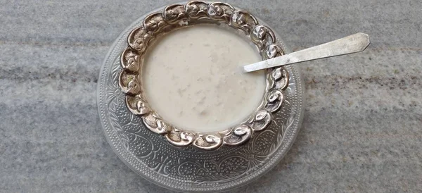 用干果装饰的奶米麦片粥 Khir 的特写 印度美味的甜点 放在银碗里关于黑色背景的顶视图 — 图库照片