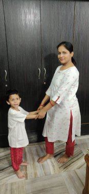 Küçük bir çocuk ve genç annesi birlikte dans ediyorlar..