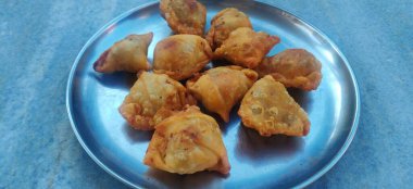 Sebzeli mini Samosa çıtır çıtır ve baharatlı Hint üçgeni şeklindeki çay saati atıştırmalığıdır. Kızarmış yeşil soğan, soğan ve ketçap ile servis edilir. Seçici odak