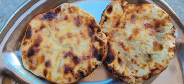 Baharatlı civciv köri veya Chola Masala veya Chana Masala veya Chole Kulche veya Cholay dilimlenmiş soğan, yeşil kişniş yaprağı ve tereyağı ile süslenmiş. Kuzey Hindistan 'daki insanların çoğunda popüler bir yemektir.