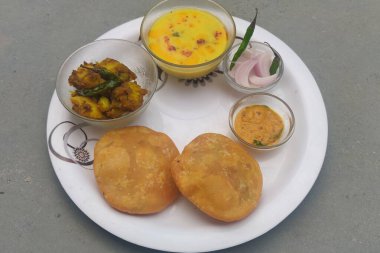 Doldurulmuş Kachori yanında patates kızartması ve yeşil soslu yeşil biber..