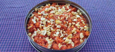 Üstünde badam pulları olan havuç halvası denen Hint tatlısı.